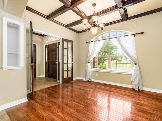 1705 Aquila Dr, Pueblo, CO 81008 - empty room featuring a chandelier, coffered ceiling, hardwood / wood-style floors, baseboards, and beamed ceiling