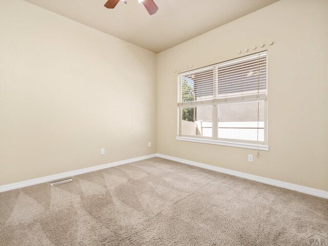 1705 Aquila Dr, Pueblo, CO 81008 - empty room featuring light carpet, a ceiling fan, and baseboards