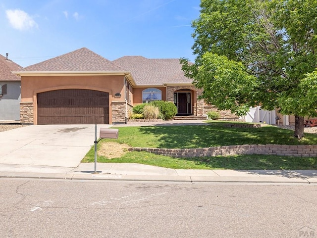 1705 Aquila Dr, Pueblo, CO 81008 - single story home featuring stucco siding, stone siding, an attached garage, and driveway
