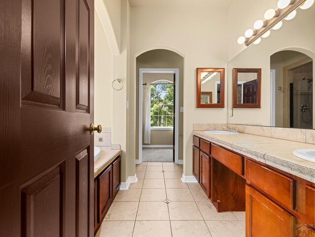 1705 Aquila Dr, Pueblo, CO 81008 - bathroom with double vanity, tile patterned floors, baseboards, and a shower