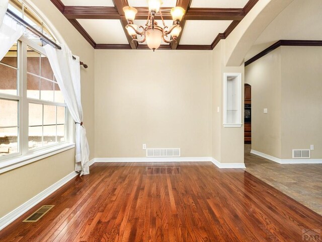 1705 Aquila Dr, Pueblo, CO 81008 - spare room with arched walkways, a chandelier, wood-type flooring, baseboards, and coffered ceiling