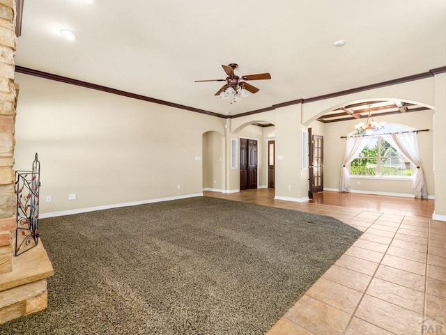 1705 Aquila Dr, Pueblo, CO 81008 - unfurnished living room with arched walkways, a ceiling fan, baseboards, tile patterned flooring, and crown molding