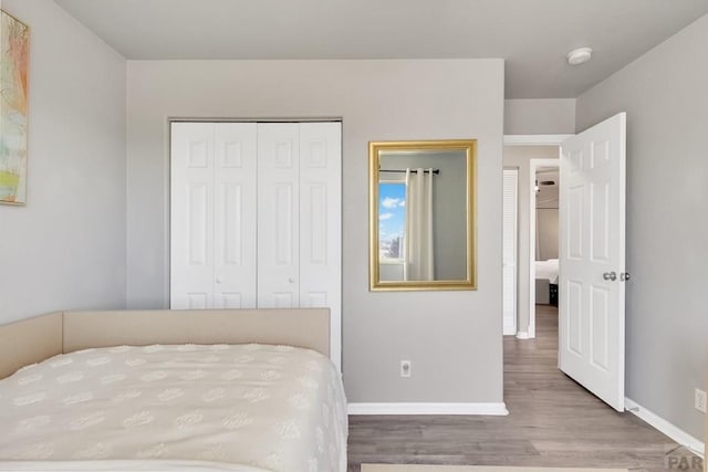 bedroom featuring a closet, baseboards, and wood finished floors