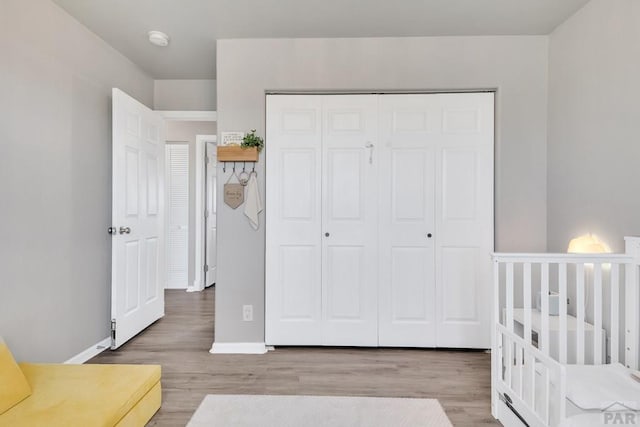 bedroom with a closet, baseboards, and wood finished floors