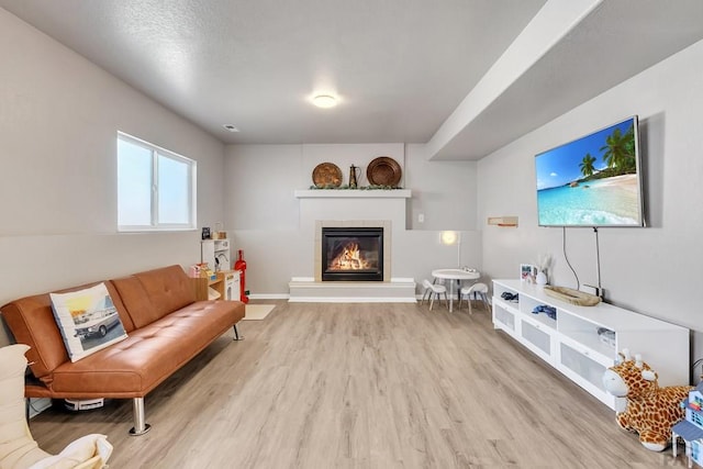 living room featuring a tiled fireplace, wood finished floors, and baseboards