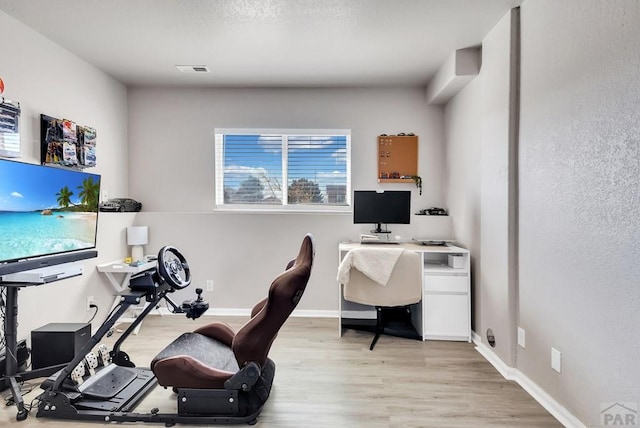 office area featuring light wood-style floors, visible vents, and baseboards