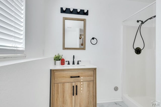 bathroom with marble finish floor, a shower stall, baseboards, and vanity