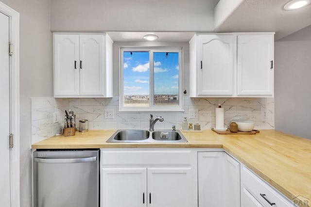 kitchen featuring stainless steel dishwasher, a sink, white cabinetry, and tasteful backsplash