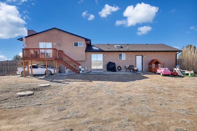 rear view of house with a patio, stairway, fence, a wooden deck, and stucco siding