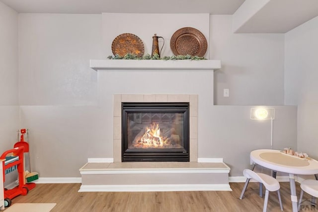 interior details featuring a fireplace, baseboards, and wood finished floors