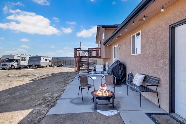 view of patio featuring an outdoor fire pit, area for grilling, and stairs