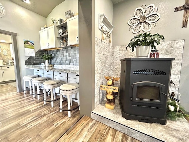 74 James Ave, Westcliffe, CO 81252 - bar with light wood finished floors, decorative backsplash, lofted ceiling, and a wood stove