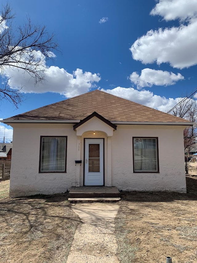 view of front of property with roof with shingles and stucco siding