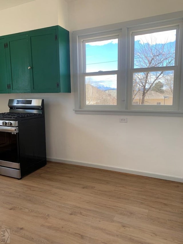 309 Walsen Ave, Walsenburg, CO 81089 - kitchen with stainless steel gas stove, light wood finished floors, green cabinets, and a wealth of natural light