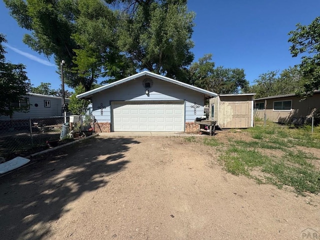 604 Townsend Ave, Olney Springs, CO 81062 - view of front of property with brick siding, an outbuilding, driveway, and a garage