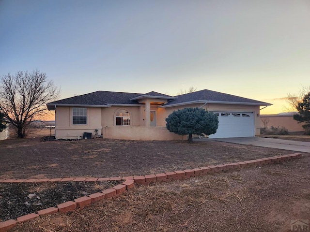 view of front facade with stucco siding, driveway, and an attached garage