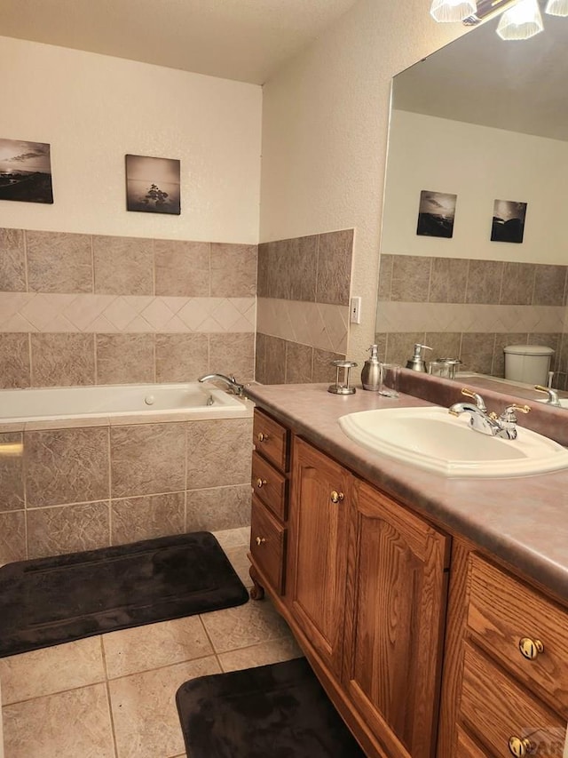 full bath featuring toilet, a garden tub, vanity, and tile patterned floors