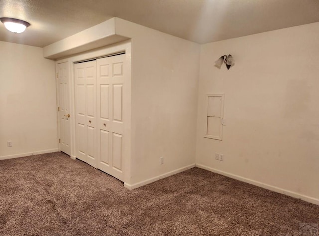 unfurnished bedroom featuring carpet, baseboards, and a closet