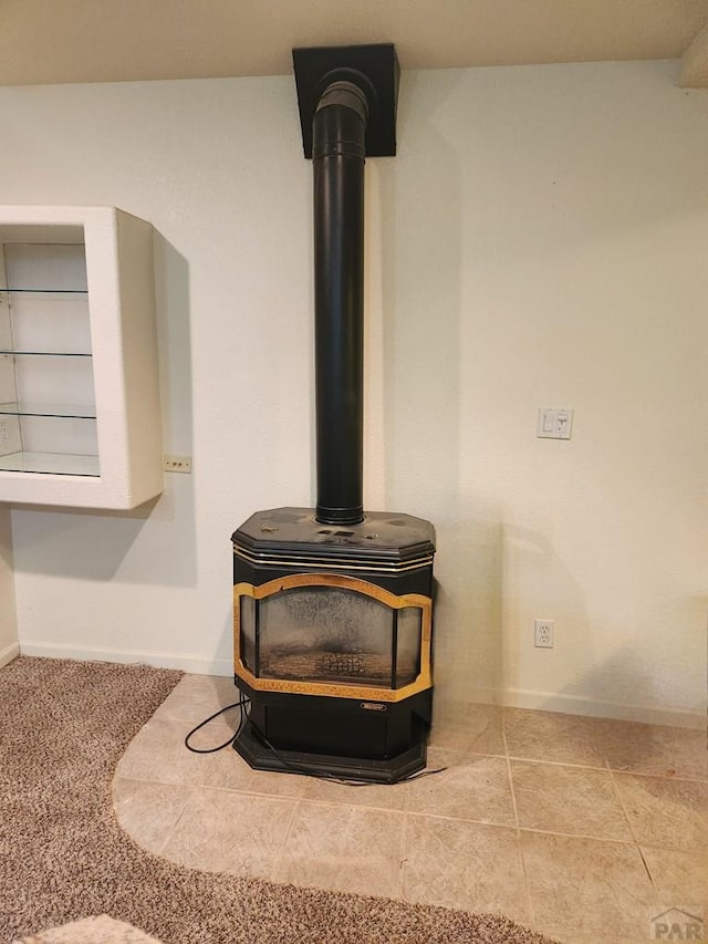 room details featuring a wood stove and baseboards