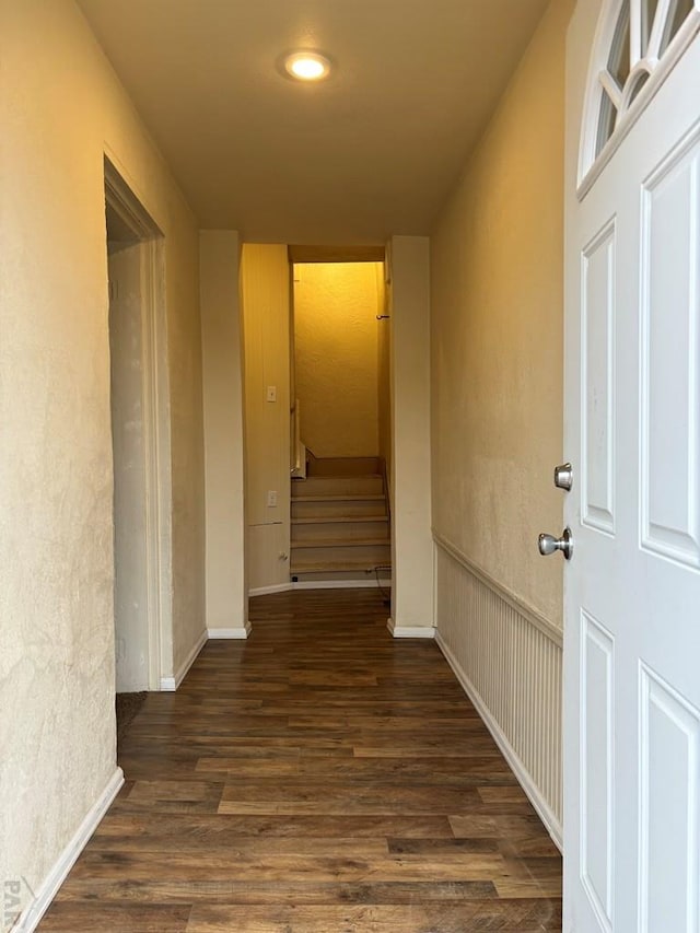 hall with dark wood-style floors and stairway