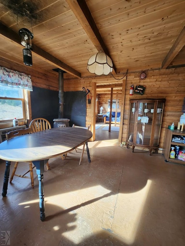 dining space with a wood stove, wooden ceiling, beamed ceiling, and wood walls