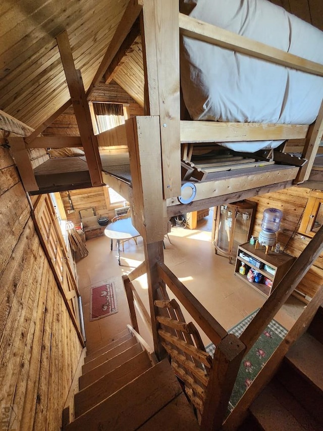 stairs featuring lofted ceiling with beams and wood finished floors