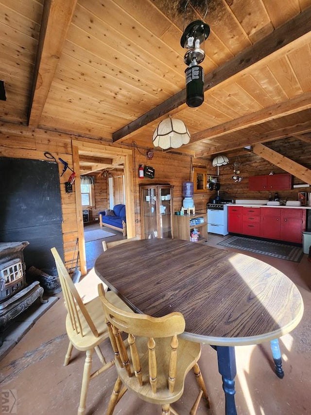 dining space featuring beamed ceiling, wooden ceiling, and wooden walls