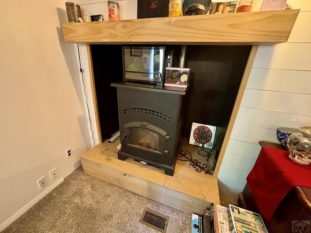 room details with a wood stove, carpet, and visible vents