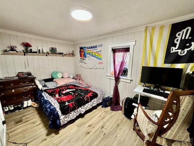 bedroom featuring crown molding and wood finished floors