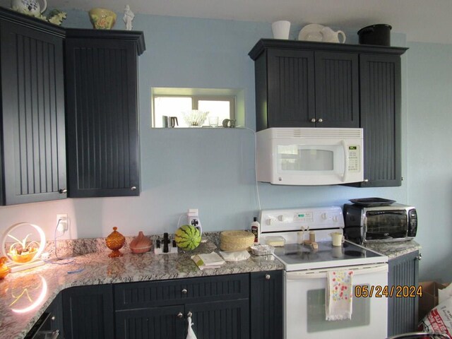 kitchen featuring light countertops, white appliances, and dark cabinets