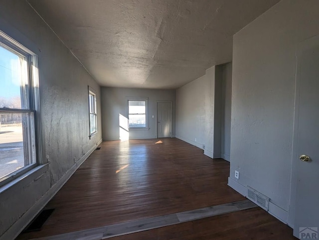 empty room with visible vents and dark wood-style flooring