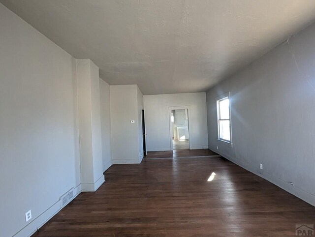 empty room with dark wood finished floors