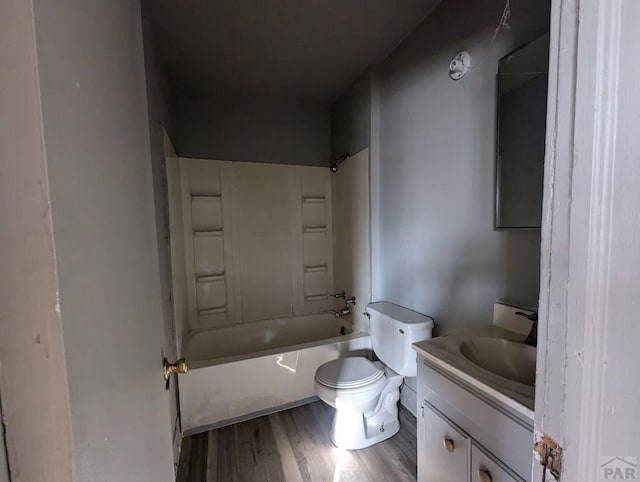 bathroom with toilet, bathing tub / shower combination, wood finished floors, and vanity