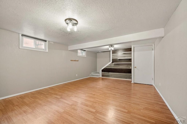 1516 Zuni Rd, Pueblo, CO 81001 - below grade area featuring a textured ceiling, light wood-type flooring, stairway, and plenty of natural light