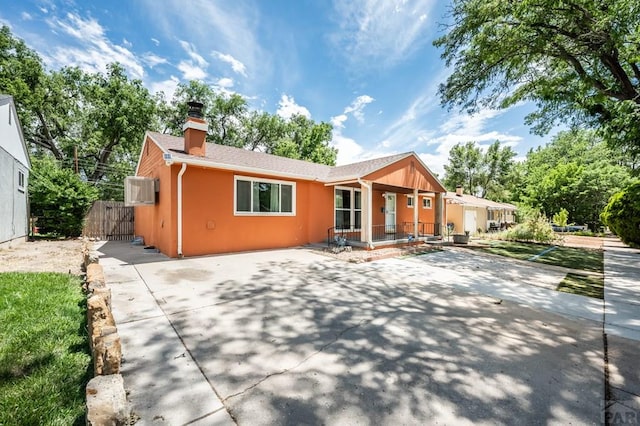 1516 Zuni Rd, Pueblo, CO 81001 - view of front facade with a chimney, a porch, and stucco siding