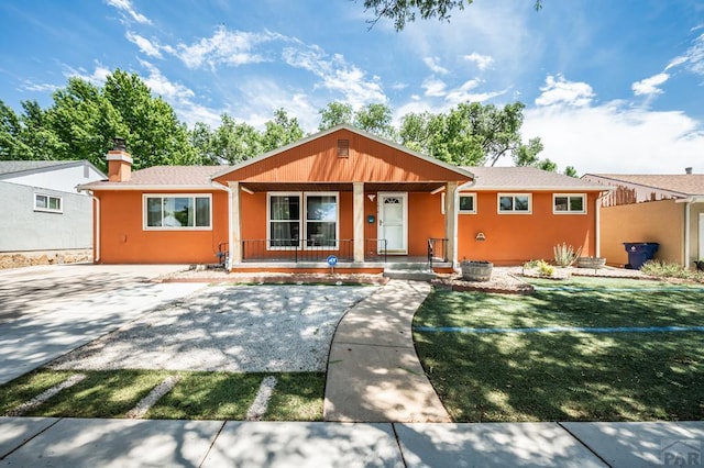 1516 Zuni Rd, Pueblo, CO 81001 - ranch-style home featuring a porch, a front yard, stucco siding, and a chimney