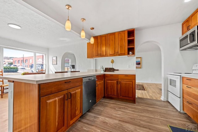 501 E Main St, Trinidad, CO 81082 - kitchen featuring stainless steel appliances, arched walkways, a peninsula, and wood finished floors