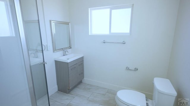 1434 E Evans Ave, Pueblo, CO 81004 - bathroom featuring vanity, toilet, marble finish floor, and baseboards