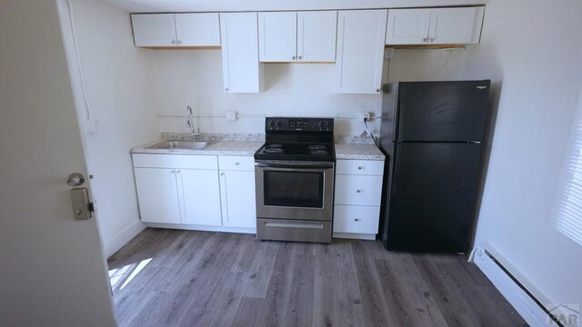 1434 E Evans Ave, Pueblo, CO 81004 - kitchen with white cabinetry, stainless steel electric range oven, a sink, a baseboard radiator, and freestanding refrigerator