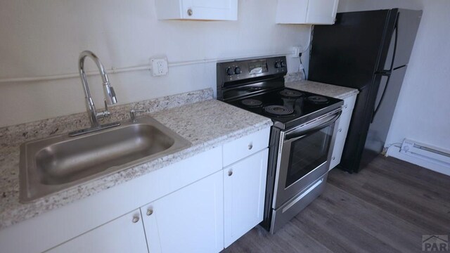 1434 E Evans Ave, Pueblo, CO 81004 - kitchen featuring a sink, white cabinets, freestanding refrigerator, electric range, and dark wood finished floors