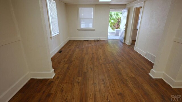 1434 E Evans Ave, Pueblo, CO 81004 - spare room featuring baseboards, visible vents, and dark wood-style flooring