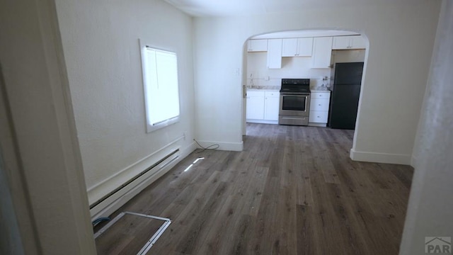 1434 E Evans Ave, Pueblo, CO 81004 - interior space featuring white cabinets, freestanding refrigerator, electric range, and baseboards