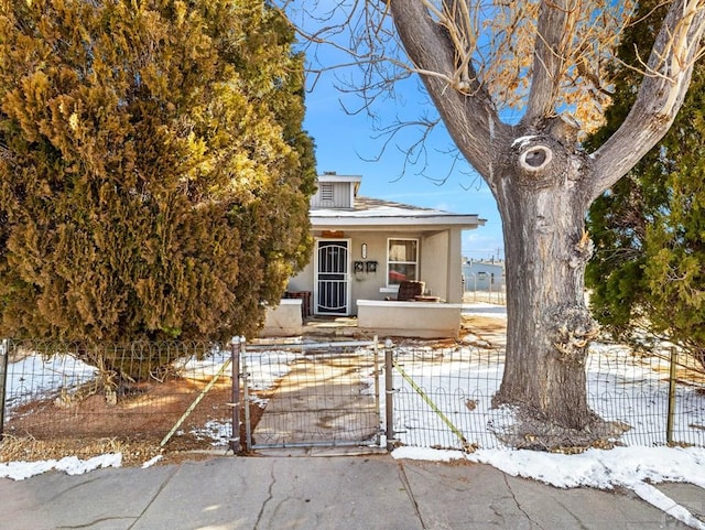 1434 E Evans Ave, Pueblo, CO 81004 - view of front of home with stucco siding, a gate, covered porch, and fence private yard