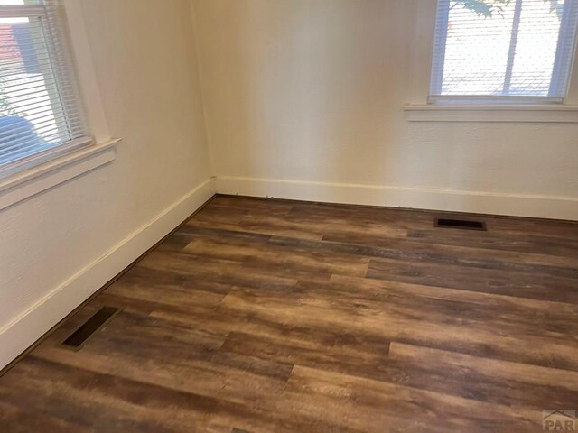 1434 E Evans Ave, Pueblo, CO 81004 - empty room with visible vents, dark wood-style flooring, and baseboards