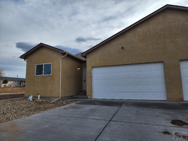710-712 Hahns Peak Ave, Pueblo West, CO 81007 - view of front of property with concrete driveway, stucco siding, and a garage