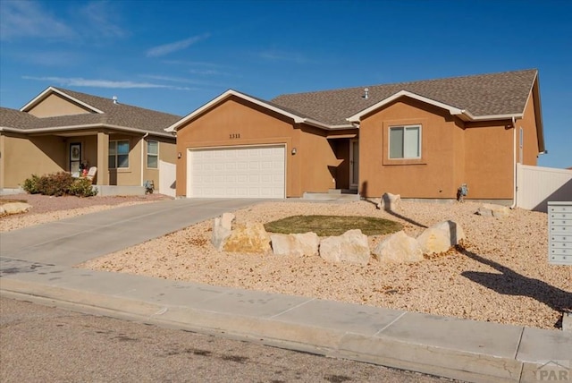 single story home with driveway, an attached garage, and stucco siding