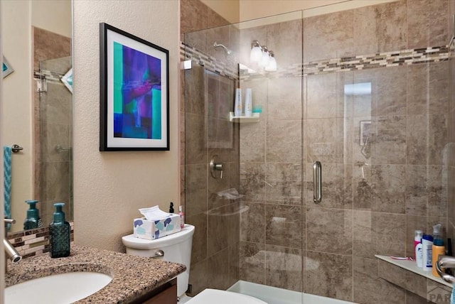 full bathroom with toilet, a shower stall, and vanity