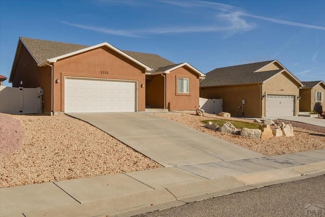 ranch-style house featuring an attached garage, driveway, and stucco siding