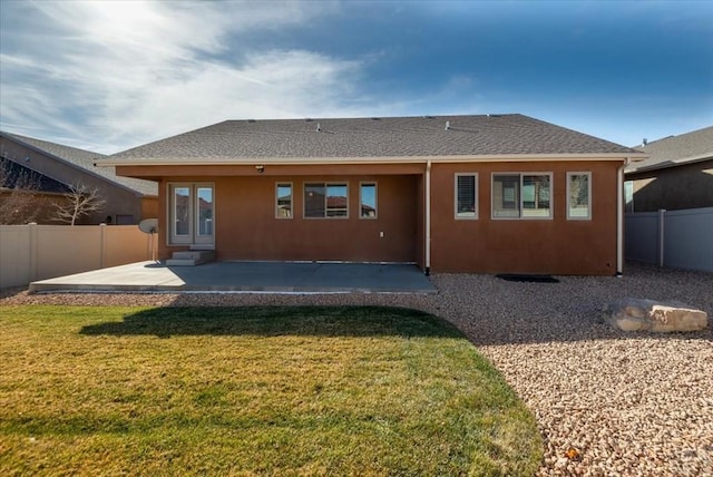 rear view of house featuring fence private yard, a patio area, a yard, and stucco siding