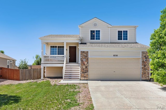8718 Silver Glen Dr, Fountain, CO 80817 - split level home with a porch, concrete driveway, an attached garage, stairway, and stone siding